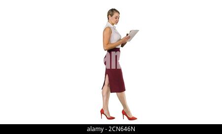 Businesswoman using electronic tab walking on white background. Stock Photo