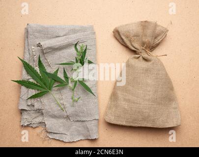 linen, green hemp leaf, brown bag on a brown wooden background Stock Photo