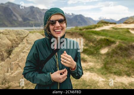 A young woman hiking in a windy valley in New Zealand, home to Mount Sunday Stock Photo