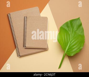 stack of spiral open notebooks with blank brown sheets on a beige background Stock Photo