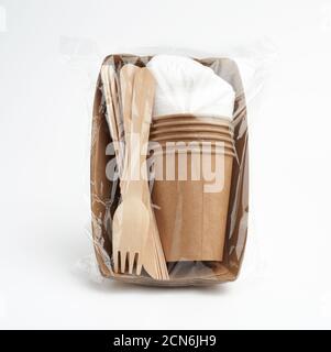 set of disposable tableware from paper craft paper in a transparent plastic bag Stock Photo