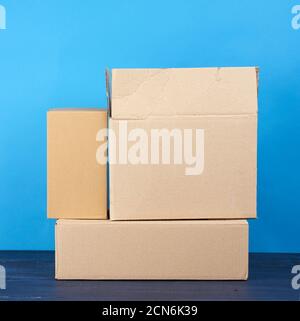 stack of cardboard boxes of brown kraft paper on a blue wooden table Stock Photo