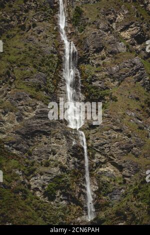 Narrow waterfall in a cliff face in New Zealand Stock Photo