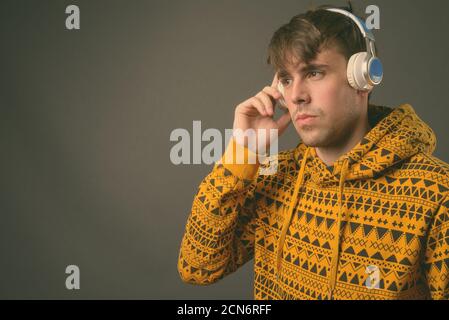 Studio shot of young handsome man against gray background Stock Photo