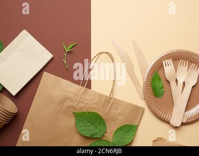 disposable paper utensils from brown craft paper and recycled materials on a brown background Stock Photo