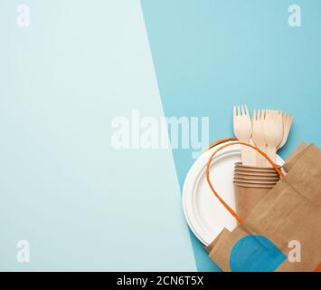 disposable paper utensils from brown craft paper and recycled materials on a green background Stock Photo