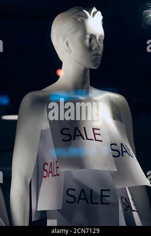 Retail sale sign attached to a mannequin in a storefront window Stock Photo