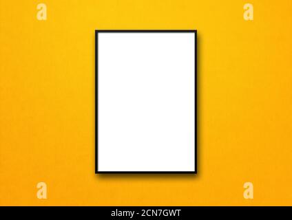 Black picture frame hanging on a yellow wall Stock Photo
