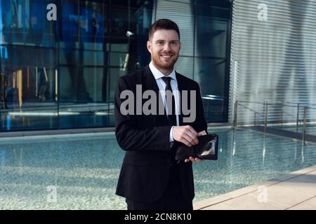 Businessman Counting Money in Wallet. Money Concept, Businessman Freelance. Wallet in hands. Watching to camera Stock Photo