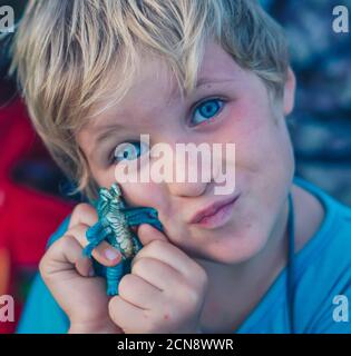 Little boy holding green dinosaur toy Stock Photo - Alamy