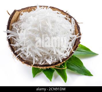 Shredded coconut flakes in the coconut shell isolated on white background. Stock Photo