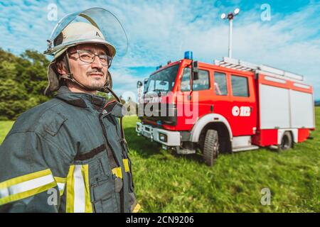 A german fireman stands near a firetruck Stock Photo