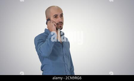 Serious arab talking on the phone on gradient background. Stock Photo