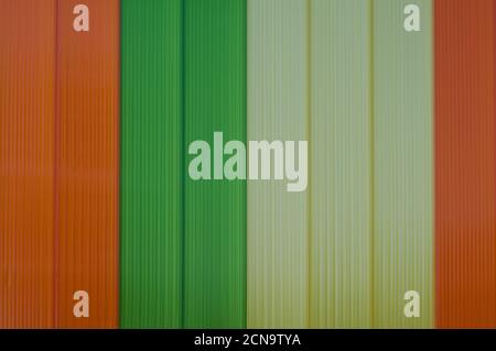 detail of some orange, green and yellow stripes on the wall of a building Stock Photo