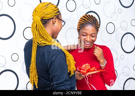 lady gifts her friend an envelope wrapped with a ribbon Stock Photo