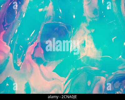 Holographic multicolored real crumpled texture background in blue and pink shades. Stock Photo