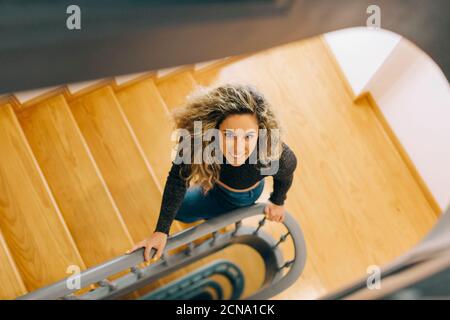 Portrait smiling young woman on wooden staircase Stock Photo