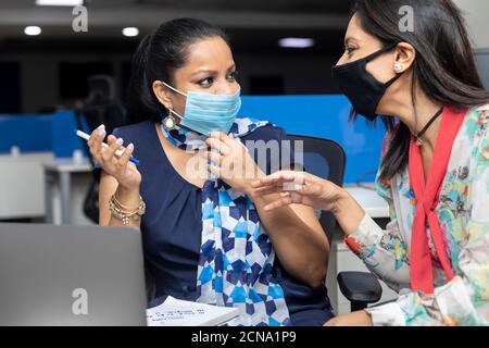 Portrait of a two Indian businesswomen having a meeting,  project discussion, corporate office environment. Stock Photo