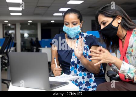 Portrait of a two Indian businesswomen having a meeting,  project discussion, corporate office environment. Stock Photo