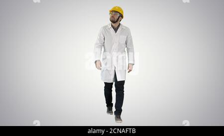 Engineer putting on protactive glasses while walking on gradient Stock Photo