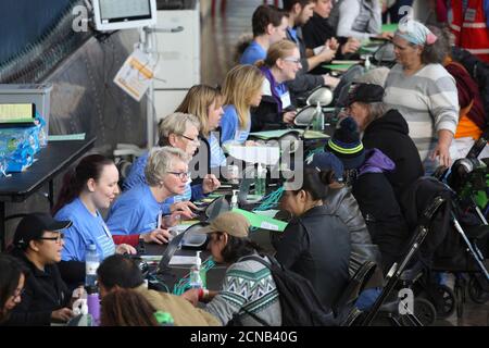 Volunteers check attendees into the Seattle/King County Clinic, a four-day event offering free dental, vision, and medical care, at Key Arena in Seattle, Washington October 28, 2016.  REUTERS/David Ryder