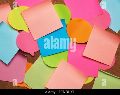 colorful paper stickers glued on brown balsa board, idea and multitasking Stock Photo