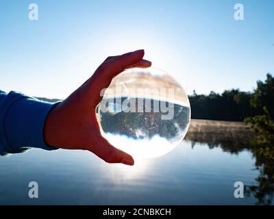 Hand hold lens. World reflection in the glass ball Stock Photo