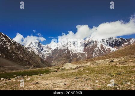 A beautiful landscape of jagged snow capped Himalayan mountain peaks in a green valley in Himachal Pradesh, India. Stock Photo