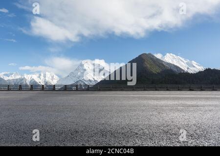 empty asphalt highway with snow mountain background Stock Photo