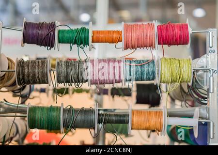 Set of spools with leather rope of different colors for sewing or crafting on  market Stock Photo
