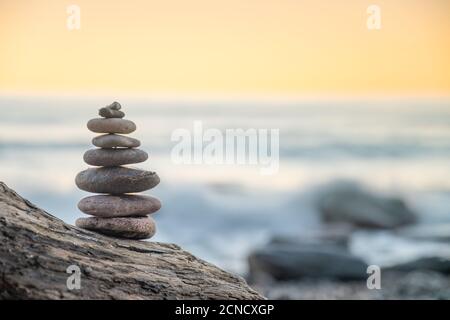 Zen balanced stones stacked on sea coast at sunset. Stock Photo