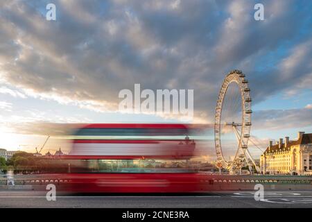 A red London bus goes past in a blur across Westminster Bridge with the London Eye and Southbank in distance, London, England, United Kingdom, Europe