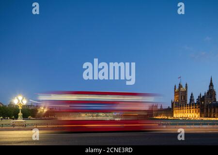 A red London bus goes past in a blur across Westminster Bridge, London, England, United Kingdom, Europe