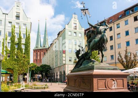 Nikolaiviertel (Nicholas Quarter) at sunset near Alexander Platz with statue of St. George Slaying The Dragon and church spires, Berlin, Germany Stock Photo