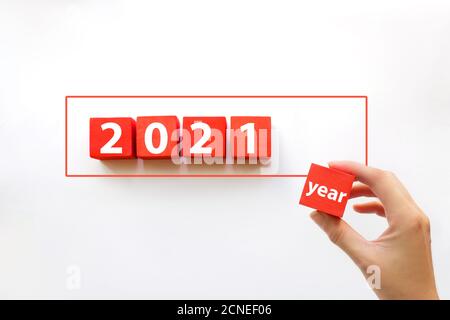 Hand arranging red blocks stacking on line with text 2021 year. Business concept for growth success process Stock Photo