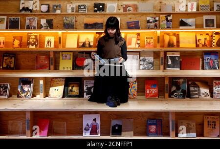 A woman reads a book at the Shinjuku branch of Book and Bed, an accommodation combined with book cafe where guests can sleep in hidden bunks built into a large bookshelf, during a photo opportunity in Tokyo, Japan September 14, 2018. REUTERS/Kim Kyung-Hoon
