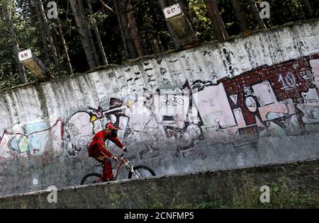 Downhill biker Kemal Mulic trains on the disused bobsled track from the 1984 Sarajevo Winter Olympics on Trebevic mountain near Sarajevo, Bosnia and Herzegovina, August 8, 2015. Abandoned and left to crumble into oblivion, most of the 1984 Winter Olympic venues in Bosnia's capital Sarajevo have been reduced to rubble by neglect as much as the 1990s conflict that tore apart the former Yugoslavia. The bobsled and luge track at Mount Trebevic, the Mount Igman ski jumping course and accompanying infrastructure are now decomposing into obscurity. The bobsled and luge track, which was also used for 
