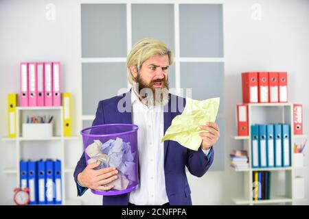 Vile work. Recover document. Office worker digging in garbage. Recover files after deletion. Businessman hold trash can. Man look for lost document. Digging in the trash. Rummaging through the papers. Stock Photo