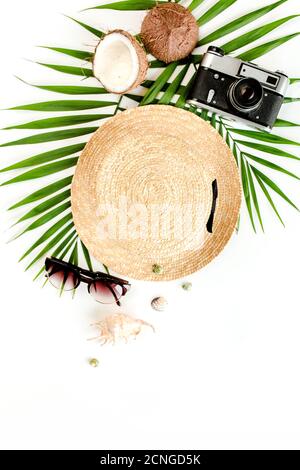 Traveler accessories, tropical palm leaf branches, straw hat on white background with empty space for text. Travel vacation concept.  Stock Photo