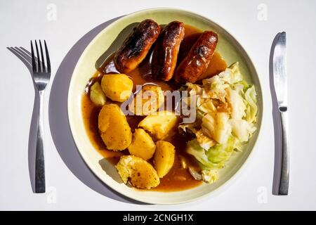 Sausages boiled potatoes and cabbage with gravy Stock Photo