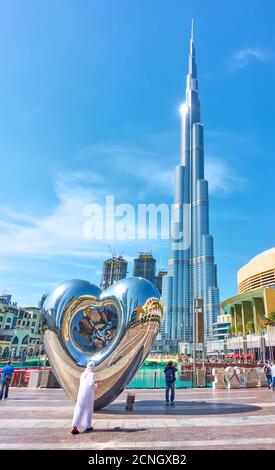 Dubai, UAE - January 30, 2020: The Dubai Steel Heart - Modern sculpture next to Burj Khalifa building and Dubai Mall, United Arab Emirates