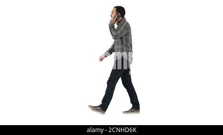 Young bearded man walking and talking on the mobile phone on whi Stock Photo