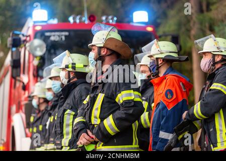 BAVARIA / GERMANY - SEPTEMBER 16, 2020: German firemen stands near a fire truck during an exercise Stock Photo