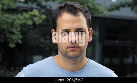 Handsome young man looking thoughtful pensive looking to camera. Stock Photo