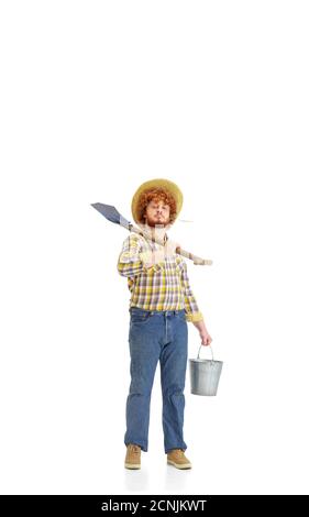 Handsome farmer, rancher isolated over white studio background. Concept of professional occupation, work, job, organic food. Copyspace for ad, text. Caucasian man with equipment for working. Stock Photo
