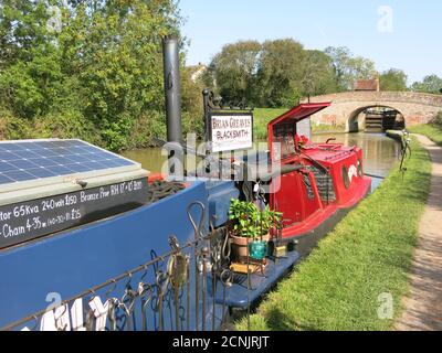 Traditional blacksmith, Brian Greaves, works on board his narrowboat on the Grand Union canal and sells his metalwork from the towpath near Braunston. Stock Photo