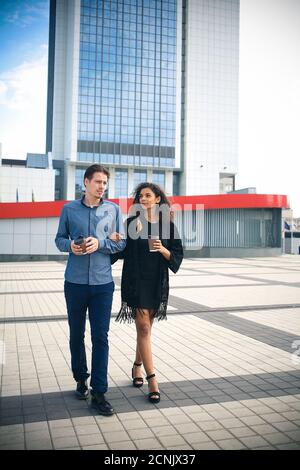 Casual meeting outside on a sunny day. Interracial couple walking at street. Stock Photo