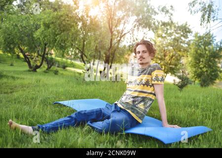 handsome stylish guy enjoys nature and dreams about something sitting in the park. peaceful sight Stock Photo