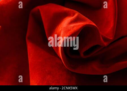 Dark red matte background of suede fabric, closeup. Velvet texture of seamless wine leather. Felt material macro. Red texture Stock Photo