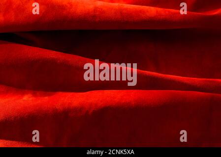 Dark red matte background of suede fabric, closeup. Velvet texture of seamless wine leather. Felt material macro. Red texture Stock Photo